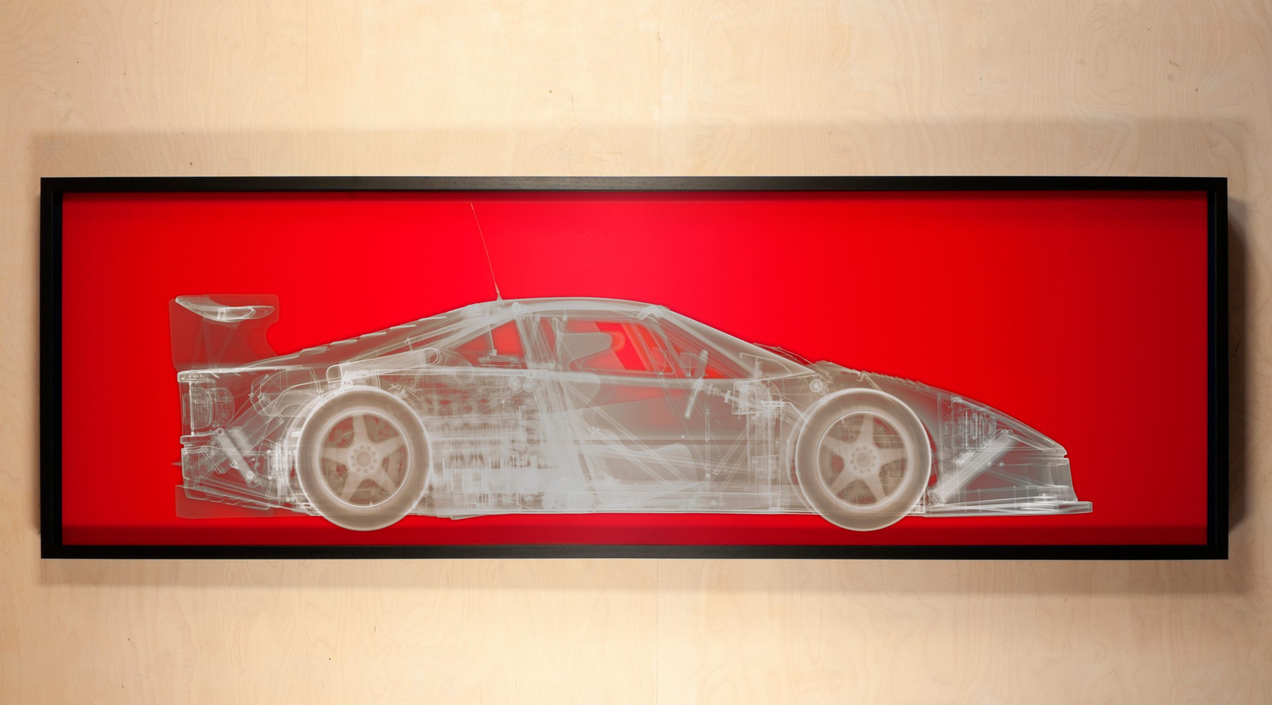 Ferrari F40 plateado sobre fondo rojo